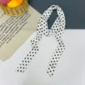Dettaglio in primo piano di sciarpa in nastro di seta bianca con classico motivo a pois. - Pois Grandi Bianco