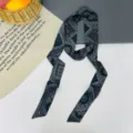 Vista dettagliata della sciarpa twilly lunga con motivo paisley nero, elegante nastro. - Rombo Paisley Nero