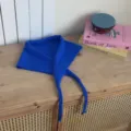 Detailed view of the royal blue knitted triangular scarf with ties, soft texture for spring. - Sapphire Blue