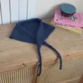 Detailed view of the dark blue knitted triangular scarf with strings for stylish autumn wear. - Dark Gray