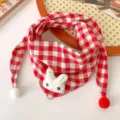 Close-up of cute baby red white plaid scarf with bunny plush detail and soft pom-poms. - Red White Rabbit Plaid Triangle Scarf