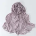 Dettaglio di una sciarpa trasparente stropicciata viola chiaro con bordo delicato e consistenza. - viola taro