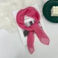 Vista dettagliata di un foulard in seta rosa vivo, sottile e posizionato con stile su una rivista. - Rosa Fucsia