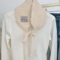Detailansicht eines süßen koreanischen Strickpullovers mit niedlichem Plüschkragen und Schal. - Gebrochenes Weiß / 15*53cm