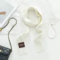 Detailansicht des weißen feinen Strick-Schals mit flachen Accessoires für Damenmode. - Weiß