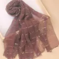 Close-up detail of shimmering pleated scarf with metallic gold square dots on soft fabric. - Dark Purple