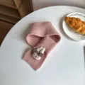 Vista detallada de bufanda de punto rosa para niños con conejito tierno, cuello cruzado cálido. - Rosa