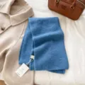 Detailed view of soft blue knitted winter scarf with cozy texture and neat flat lay style. - Lake Blue