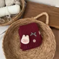 Gemütlicher Kinder-Knitted-Halswärmer in Dunkelrot mit süßem Hasen-Patch. Detailansicht. - Burgunderrot