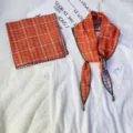 Close-up detail of the orange plaid cotton scarf and square kerchief set styled neatly. - Cotton Combination Set / Orange Red