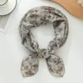 Detailaufnahme eines vintage blumigen quadratischen Tuchs, eleganter leichter Stoff gebunden. - Helles Kaffee Gardenie
