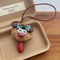 Gros plan sur le pendentif chiot en gousse de haricot fait main, charmant détail de sac. - Pendentif chiot avec nœud / Bronze