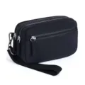 Close-up detail of the black nylon multi-zipper wrist bag, showing the durable hardware. - Black