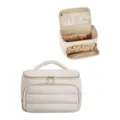 Detailed view of the beige quilted cosmetic bag showcasing interior mesh pockets and zip storage. - Off White