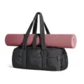 Detailed view of women puffy quilted gym duffel bag in black with integrated pink yoga mat. - 43×22×19 cm / Black 2