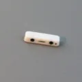 Detail view of a white double-hole acrylic spacer bead with cute face pattern for DIY jewelry crafts. - 5x17mm