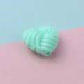 Detail shot of mint green twisted heart acrylic loose bead for jewelry making and phone charms - Lake Blue