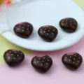 Vue détaillée de perles acryliques marron foncé en forme de fraise avec pois roses, trou. - Café Fraise