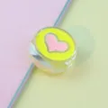 Close-up of 21mm transparent acrylic bead with neon green and pink heart oil-drop design. - Yellow