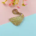 Close-up detail view of the holographic gradient glitter swan resin cabochon DIY craft accessory. - Khaki