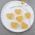 Detail view of yellow acrylic sugar heart beads, showing hole and texture for DIY jewelry. - Style 3 Yellow