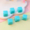 Close-up of 8mm diagonal hole turquoise acrylic square beads, ideal for DIY jewelry parts. - Lake Blue