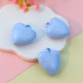Close-up detail of light blue 3D heart-shaped baked paint pendant charms on a cute cloud tray. - 27mm Light Blue