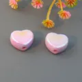 Close-up view of glossy pink heart beads with straight holes, ideal for custom jewelry making. - Light Purple
