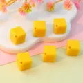 Close-up of yellow diagonal drilled acrylic square beads, perfect for DIY jewelry and phone chains. - Yellow
