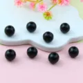 Close-up of glossy black round acrylic beads with center holes, ideal for DIY jewelry crafting. - 8mm / Black
