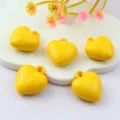 Close-up of glossy yellow heart acrylic pendants, smooth surface with top hanging loop. - Yellow
