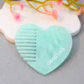 Acrylic heart-shaped comb detail view, mint green pattern with Good Luck letter print. - Lake Blue