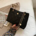Sac à bandoulière matelassé noir pour femme, sac élégant avec chaîne dorée et charm fleur. - Noir