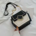 Sac à bandoulière bicolore, design hexagonal noir et blanc avec chaîne élégante et fermoir en métal. - Noir