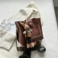 Borsa a secchiello retrò in pelle marrone con ciondolo coniglio lavorato a maglia. - con portachiavi / Caffè