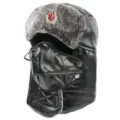 Detailansicht der schwarzen Leder Ushanka Mütze mit Kunstfell und rotem Stern. - Einheitsgröße / Schwarz + Sowjetisches Abzeichen
