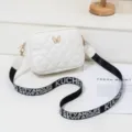 Chic white quilted crossbody bag featuring a metal butterfly and chic black strap. - White
