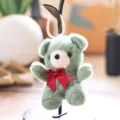 Close-up of fluffy green teddy bear plush pendant with red bow detail and pearl hanging loop. - Green / 13cm