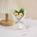 Detail view of handmade crochet mini flower bouquet wrapped in cute summer plaid paper with ribbon. - Light Yellow