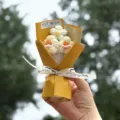 Close-up detail of handcrafted crochet flower bouquet with yellow wrapping and ribbon. - Yellow