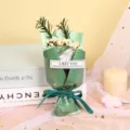 Close-up detail shot of the mini soap flower bouquet wrapped in green paper with ribbon gift. - Scottish Green