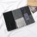 Detailed view of the cozy plaid cashmere-feel scarf with stylish fringes and brand tag design. - 黑白灰撞色格子