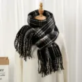 Vue détaillée d'une écharpe d'hiver à carreaux douce avec franges et motif classique. - Plaid Noir