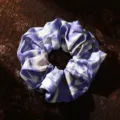 Primo piano dettagliato di un elastico per capelli in tessuto viola con motivo etnico. - Viola