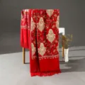 Vista dettagliata di uno scialle etnico rosso ricamato effetto cashmere con frange. - Rosso