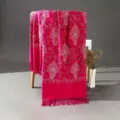 Close-up of vibrant pink ethnic shawl showcasing delicate white floral embroidery and tassel details. - Rose Red