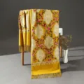 Vista dettagliata di una sciarpa ricamata in stile etnico con intricati motivi floreali. - Giallo