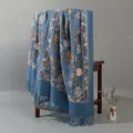 Vista dettagliata della sciarpa blu ricamata effetto cashmere con motivo floreale e frange. - Blu