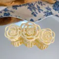 Close up of a cream white triple rose hair claw clip, matte floral design for hair. - Yellow