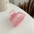 Detailed close-up view of the translucent pink acrylic hair claw clip showcasing glossy texture. - Pink